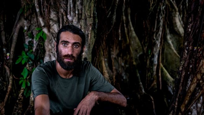 Бехруз Бучани сидит под деревом на острове Манус