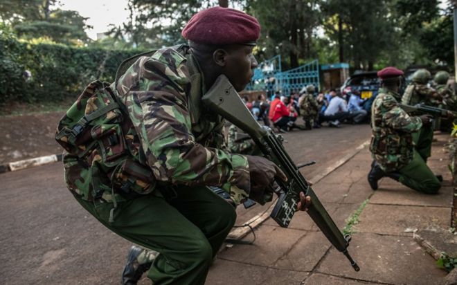 Кенийские силы безопасности укрываются после того, как 15 января 2018 года они услышали выстрелы из гостиничного комплекса Дусит