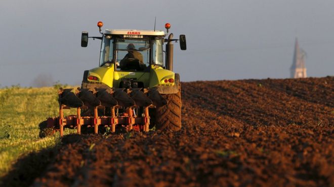 Французский фермер водит трактор и пашет поле