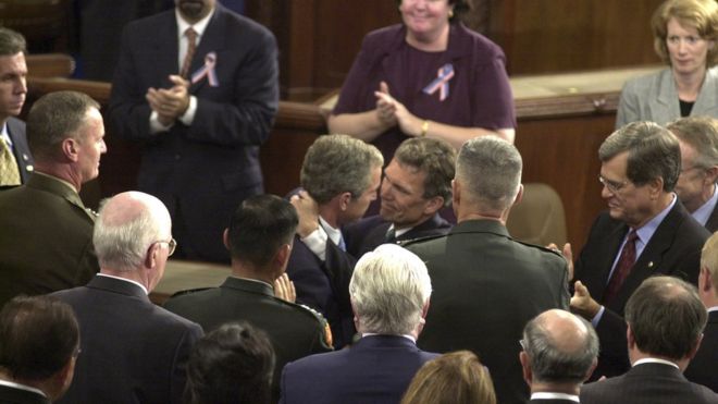 Тогдашний президент Буш обнимается с лидером большинства в демократическом сенате Томом Дэшлом после событий 11 сентября