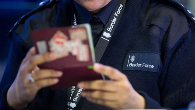 Офицер пограничных войск проверяет паспорт