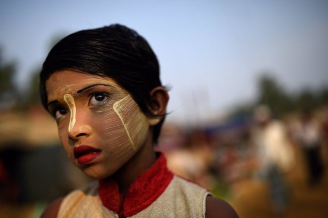 Девочка-беженка из рохингья по имени Руфия Бегум, 9 лет, позирует фотографу, когда она носит пасту Танака в лагере Балухали на базаре Кокса, Бангладеш