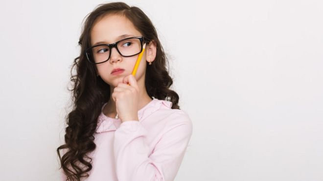Niña piensa con un lápiz.