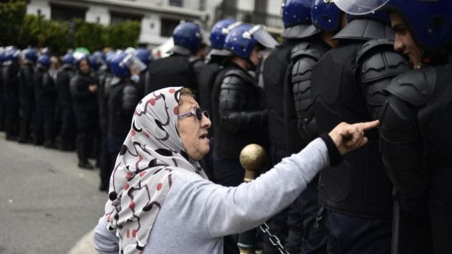 إمرأة مسنة تتحدث إلى قوات الأمن الجزائرية خلال الاحتجاجات الأخيرة