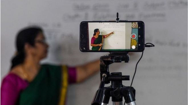 A school teacher gives a live streaming online class at a government school