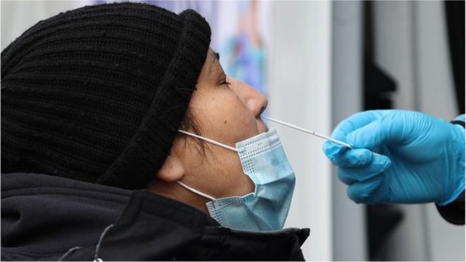 A woman is getting a Covid-19 test at a Covid-19 testing center next to the Queens Hospital Center as hundreds of residents line up to get Covid-19 test in Queens of New York, United States on December 28, 2021