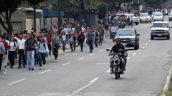 Люди, идущие по улицам Каракаса во время продолжительных отключений электроэнергии март 2019 года
