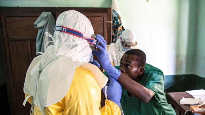Медицинские работники носят защитное снаряжение, когда они готовятся лечить подозреваемых пациентов с Эболой в Бикоро Больнице 13 мая 2018 года.