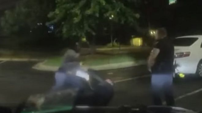 Два полицейских борются с Райшардом Бруксом на земле перед тем, как его застрелили