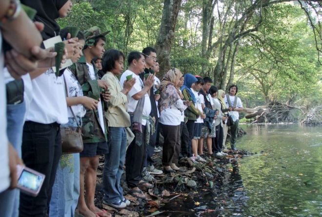 Люди молятся на берегу реки поминальной службы по потерянным слонам