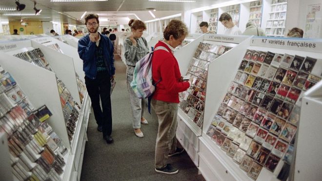 Покупатели смотрят музыкальные кассеты, выставленные в магазине в Париже 28 августа 1987 г.