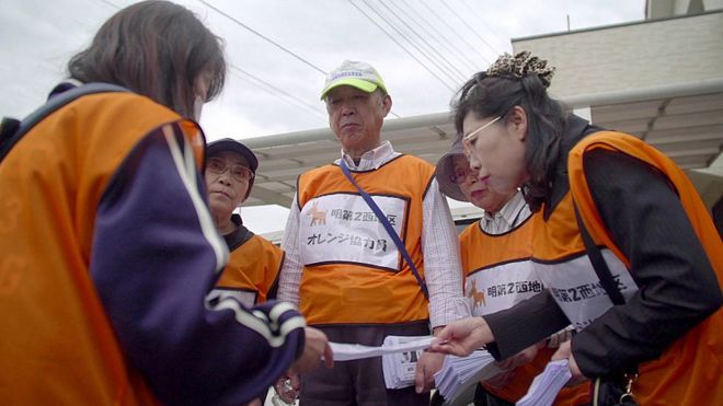 Команды по информированию о деменции по соседству в Мацудо ходят в городские двери, проверяя, что люди в безопасности