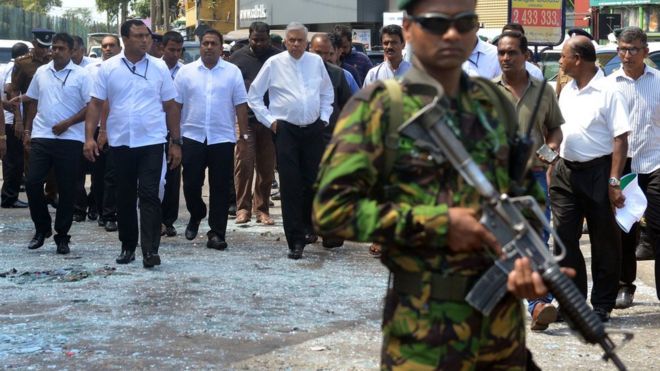 Sri Lankan Prime Minister Ranil Wickremesinghe (C) arrives to visit the site of a bomb attack at St. Anthony"s Shrine