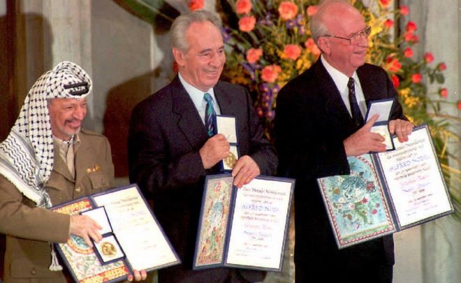 Лидер ООП Ясир Арафат, (L) министр иностранных дел Израиля Шимон Перес и премьер-министр Ицхак Рабин (R) демонстрируют свою совместную Нобелевскую премию мира 1994 года в Осло 10 декабря в знак признания их исторического соглашения об автономии