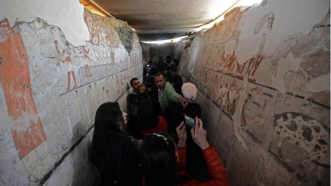 Египтяне смотрят на хорошо сохранившиеся и редкие настенные росписи внутри гробницы жрицы Старого Царства в Саккаре, на плато Гиза на южной окраине Каира, которая была открыта 3 февраля 2018 года,