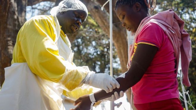 A nurse takes care of cholera patients during a visit of Zimbabwe Minister of Health,