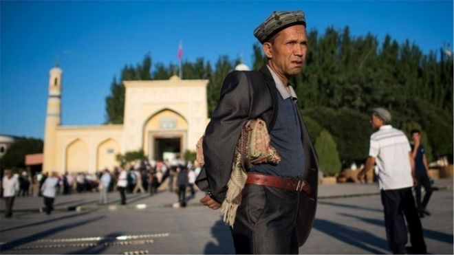 A man carries a prayer mat in Kashgar
