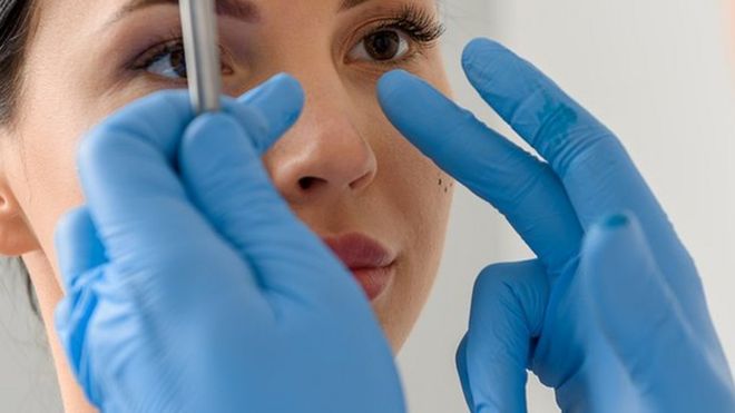 woman having her nose examined