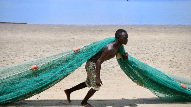 Рыбак тянет сеть на главном пляже 8 марта 2018 года в Мосимбоа-да-Прая, Мозамбик.