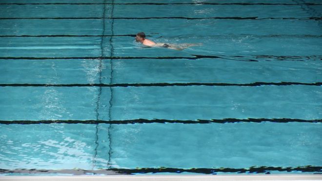 Мужчина плавает в бассейне