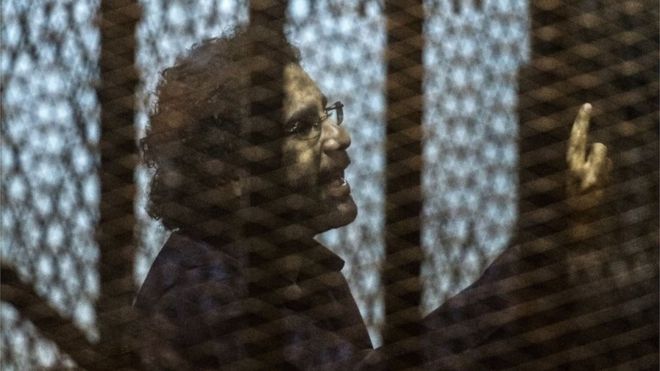 Египетский активист и блогер Алаа Абдель Фаттах в клетке обвиняемого во время судебного разбирательства в Каире 23 мая 2015 года