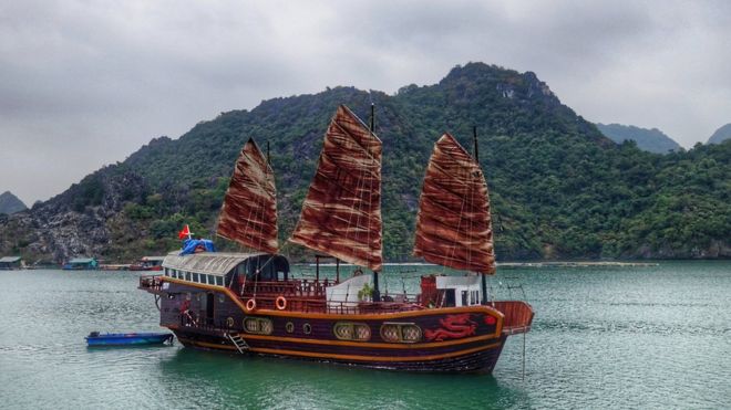 Navio chinês no mar, com serra atrás