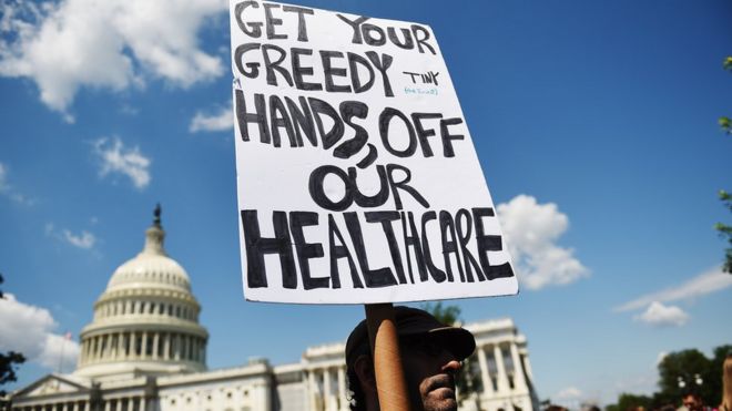 A protester holds a sign during a demonstration opposing the repeal of the Affordable Care Act and its replacement on Capitol Hill, Washington DC, 21 June 2017