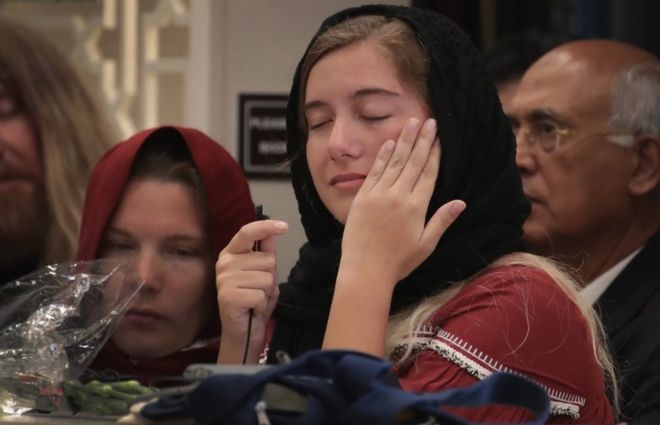 Молодая девушка вытирает слезу на службе в честь жертвы стрельбы Сабика Шейх в Стаффорде, штат Техас