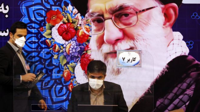 Iranian electoral officials sit in front of a picture of Ayatollah Ali Khamenei while they register candidates for the presidency at the interior ministry in Tehran, Iran (11 May 2021)