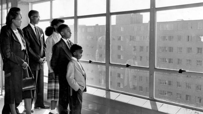 Одна из первых семей, переехавших в Pruitt Homes, осматривает закрытую игровую площадку на верхнем этаже здания по улице О'Фаллон-стрит, 2431 в октябре 1954 г.