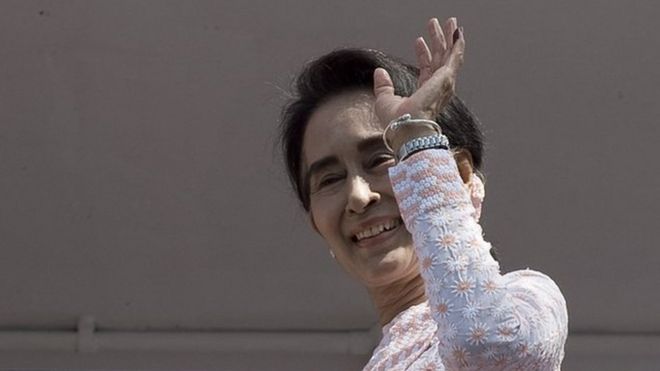Myanmar opposition leader Aung San Suu Kyi waves to a small crowd and the media after delivering a speech from the balcony of the National League of Democracy (NLD) headquarters in Yangon on 9 November 2015.