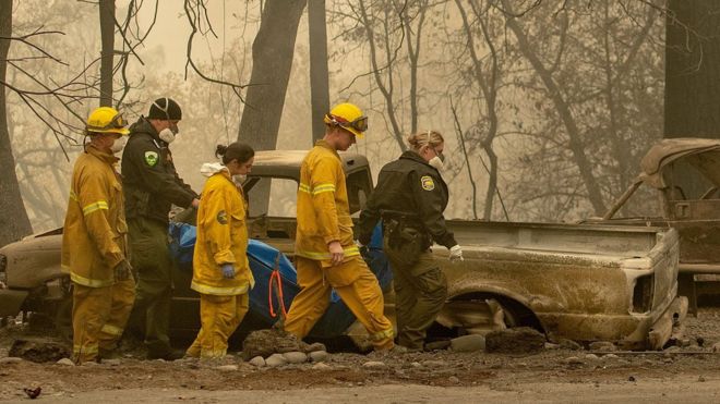 Спасательные бригады проходят через сожженные останки Рая в Калифорнии, ноябрь 2018 года