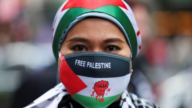 A woman who identified herself as "Ash from Malaysia" looks on during a protest in solidarity with Palestinians, in London