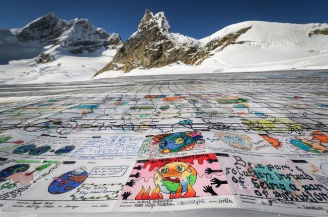 Аэрофотоснимок показывает огромный коллаж рисунков об изменении климата, выложенный на леднике Алеч в швейцарских Альпах