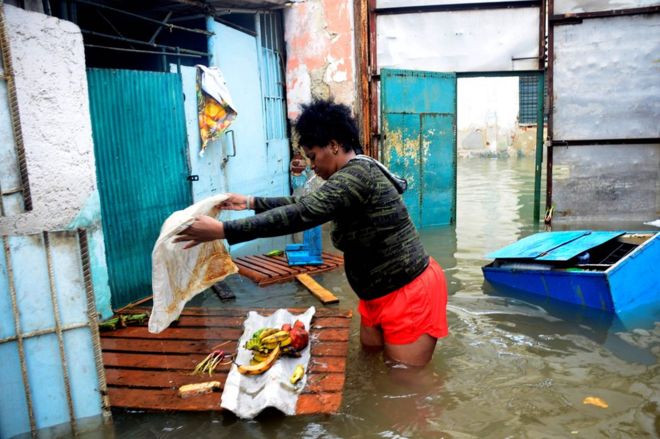 Женщина пытается спасти еду из своего затопленного дома в центре Гаваны, Куба, 10 сентября