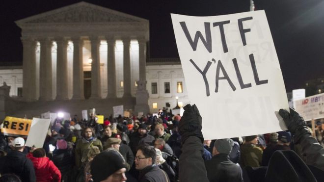 The US Supreme Court, seen in the background, is obstructed by a protesters's sign reading "WTF y'all"