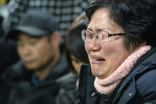 Член семьи пострадавшего в результате катастрофы в Севоле плачет во время спасательных работ в море у острова Джиндо, Южная Корея, 23 марта 2017 года.