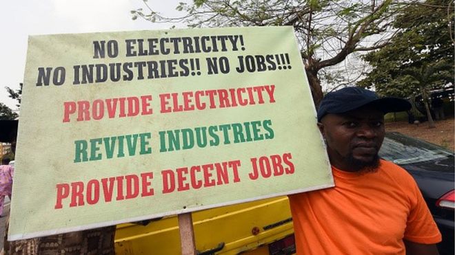 Мужчина держит плакат с надписью «Нет электричества! Нет промышленности! Нет работы !!! Обеспечьте электричество, возродите отрасли, обеспечьте достойные рабочие места »во время демонстрации протеста против повышения цен на электроэнергию на 45 процентов 8 февраля 2016 года в Лагосе
