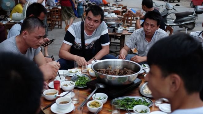 Люди едят собачье мясо в ресторане в Юйлине, на юге Китая, в провинции Гуанси (9 мая 2016 года)