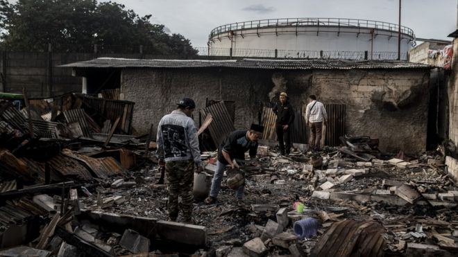 Sejumlah warga di dekat permukiman penduduk yang hangus terbakar dampak kebakaran Depo Pertamina Plumpang di Jalan Koramil, Rawa Badak Selatan, Koja, Jakarta, Sabtu (04/03). Belasan warga dilaporkan menjadi korban jiwa dalam peristiwa itu.