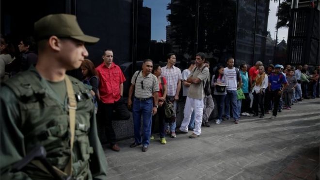 Люди выстраиваются в очередь, чтобы войти в филиал Banco Mercantil в Каракасе, Венесуэла 13 декабря 2016 года.
