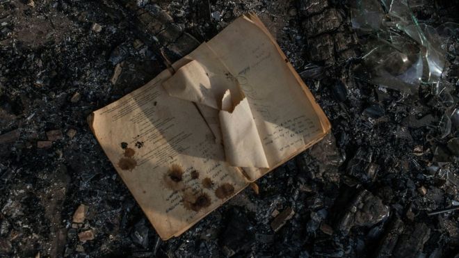 Книга в пепле классной комнаты школы, подожженной в Лимпопо, Южная Африка - май 2016 года