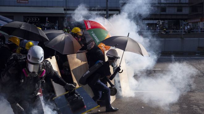 Protesters react as Hong Kong police fire tear gas in the Admiralty district (5 August)