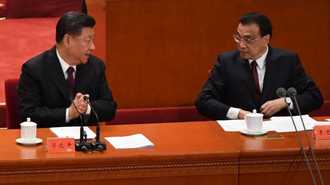 China's President Xi Jinping (L) talks with Premier Li Keqiang during a celebration meeting marking the 40th anniversary of China's "reform and opening up" policy at the Great Hall of the People in Beijing on December 18, 2018.