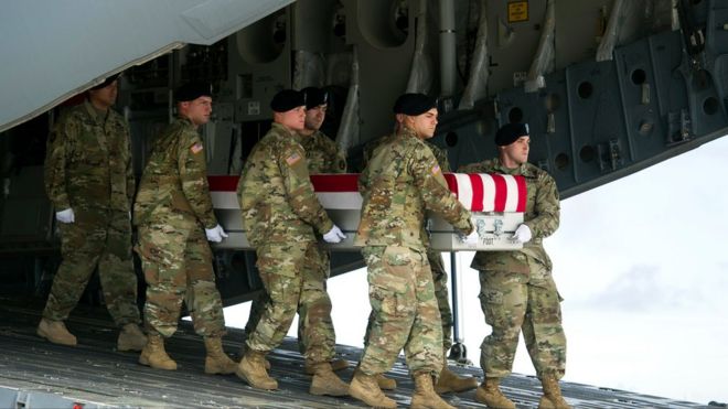 Переносная армейская команда переносит раздаточную коробку с останками сержанта Дугласа Райни из транспортного самолета в пятницу, 21 октября 2016 года, на авиабазе Дувр, штат Делавэр, США.