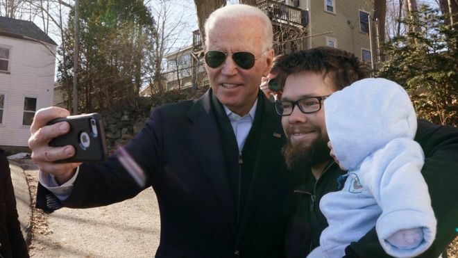 Кандидат в президенты от Демократической партии и бывший вице-президент Джо Байден приветствует мужчину с младенцем после предвыборной кампании в Сомерсворте, штат Нью-Гэмпшир, США, 5 февраля 2020 г.