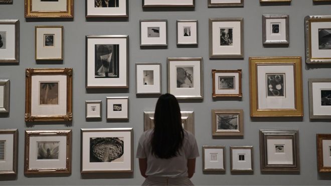 Сотрудник позирует перед фотографиями, принадлежащими Элтону Джону, во время предварительного просмотра прессы для радикального глаза: модернистская фотография из коллекции сэра Элтона Джона в Tate Modern