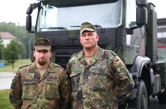 Капрал Кристофер Зайдель (слева) и старший сержант Фридеман Фришко (справа) стоят перед своим армейским грузовиком