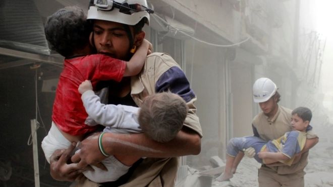 Члены гражданской обороны спасают детей после авиаудара правительственных сил в районе Аш-Шаар в Алеппо