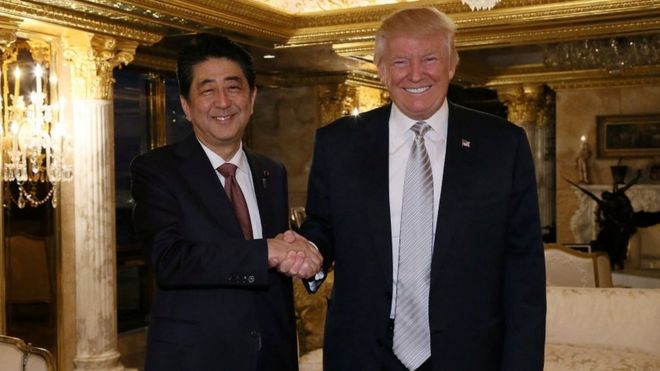 Shinzo Abe shakes hands with Donald Trump